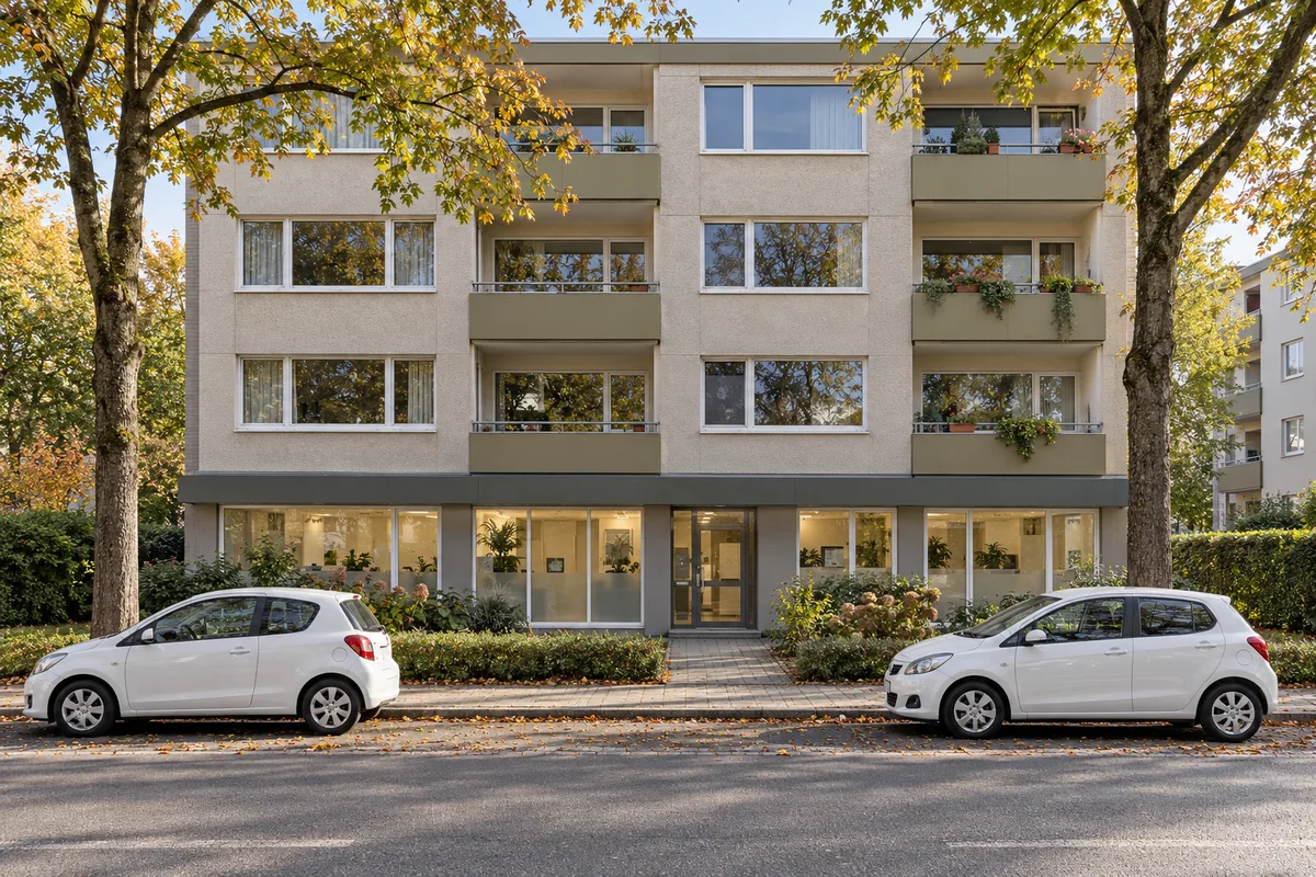 Stadthaus mit Büro eines ambulanten Pflegedienstes im Erdgeschoss, Dienstwagen vor der Tür und Wohnungen mit Balkonen darüber