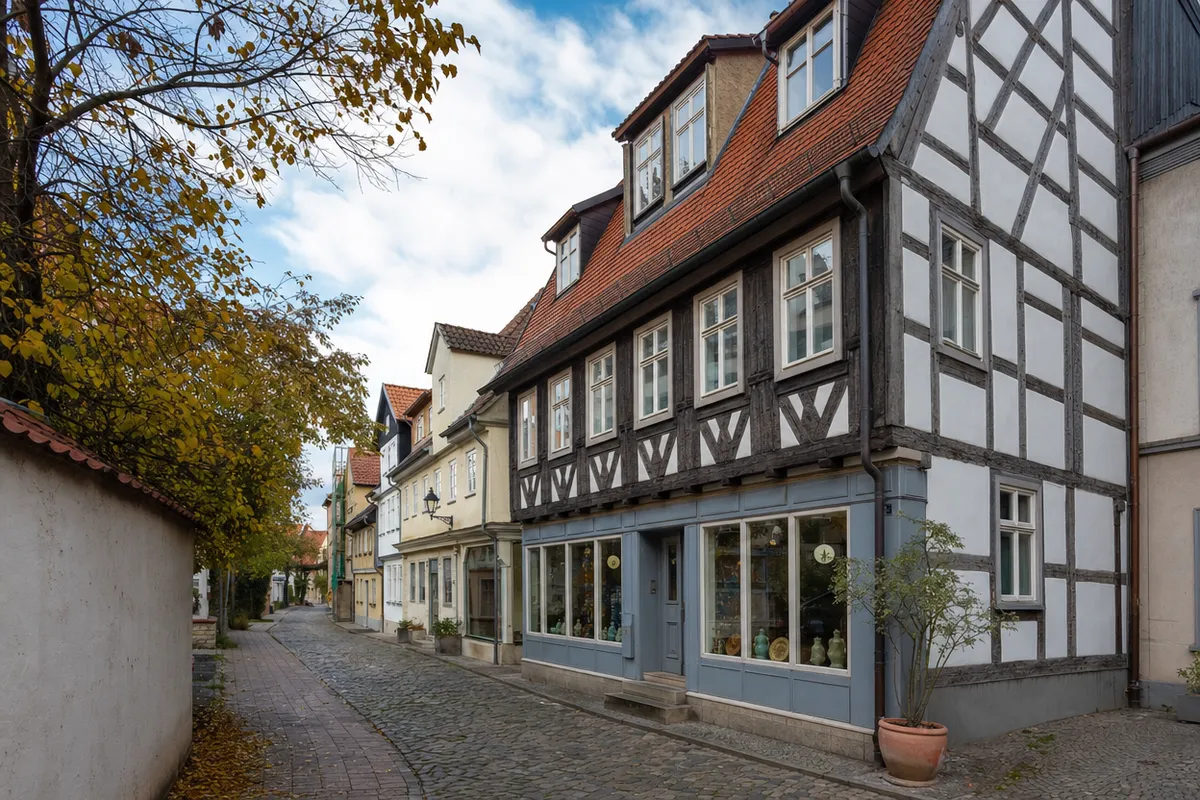 Altes Fachwerkhaus mit bündig sitzenden Fenstern und kleinem Laden im Erdgeschoss in einer schmalen Gasse der kleinteiligen Erfurter Altstadt