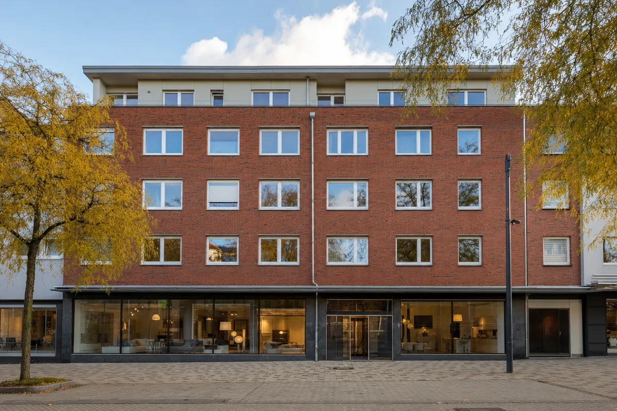 Wohn- und Geschäftshaus der Nachkriegszeit aus Backstein mit Staffelgeschoss, Flachdach und durchgehender Ladenfront an einer Fußgängerzone in Kiel